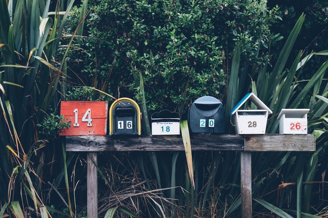 a series of mailboxes with different numbers on wooden posts